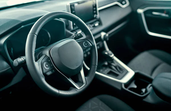 Interior view of car with black salon. Luxury car interior. Steering wheel, shift lever and dashboard.