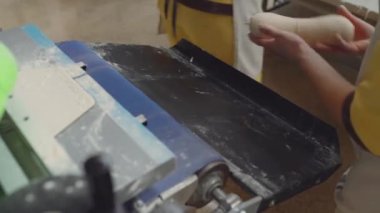 Taze ürünleri olan ekmek fırını gıda fabrikası üretimi. Otomatik fırın ürünleri üretimi. Fırıncı adam ekmek üretim hattında çalışıyor..