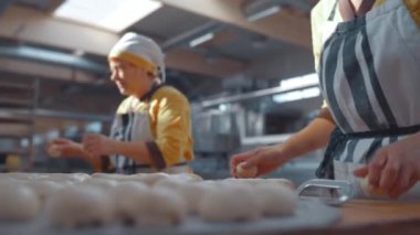 Fırıncı tatlı hamur işleri yontuyor. Fırın ürünleri üretimi. Ekmek pişirme fabrikası.