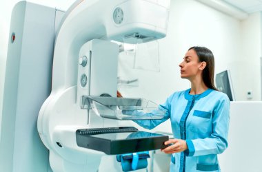 Kadın bir doktor modern bir hastane laboratuarındaki bir sonraki hastanın muayenesi için mammografi hazırlıyor. Sağlık ve Tıp Kadınları Konsepti.