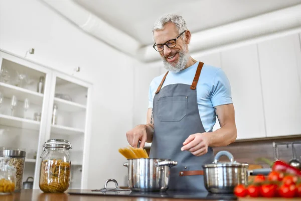 Önlüklü Yaşlı Bir Adam Mutfakta Makarna Hazırlıyor Vejetaryen Vejetaryen Sağlıklı — Stok fotoğraf