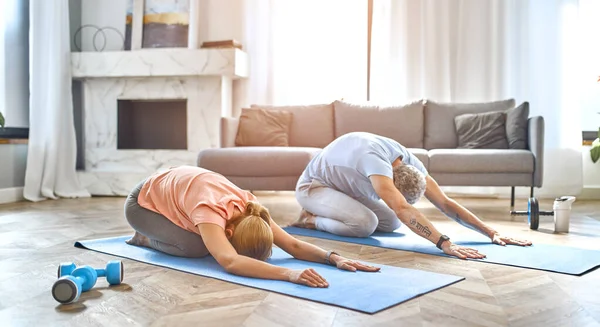 健身和健康的生活方式概念 一对成熟的夫妇在家里做运动或瑜伽 如何在检疫中保持健康 — 图库照片