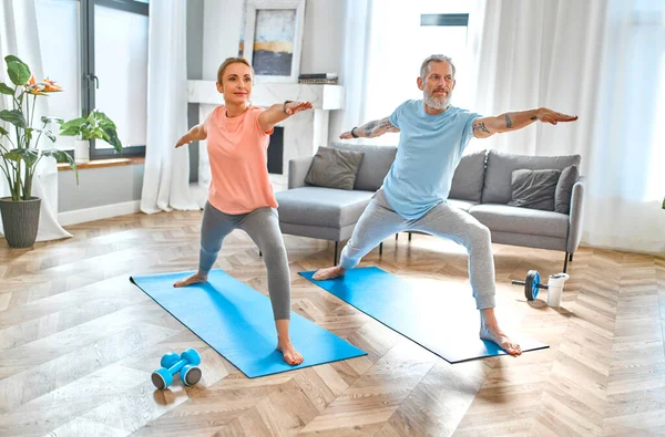 Spor, spor ve sağlıklı yaşam tarzı konsepti. Yetişkin bir çift evde egzersiz ya da yoga yapıyor. Karantinada nasıl sağlıklı kalınır?.
