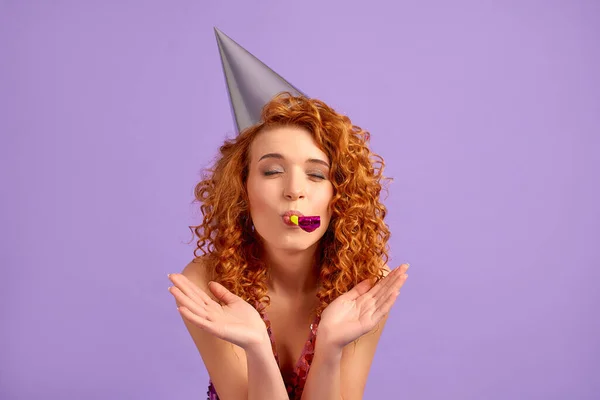 Redhead Woman Shiny Dress Party Cap Blowing Whistle Isolated Purple — Stock Photo, Image