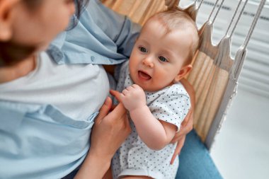 Sevgi dolu bir anne, yeni doğmuş bebeğini evde taşıyor. Anne ve çocuğu bir hamakta. Anne ve bebek güneşli yatak odasında oynuyorlar. Ebeveyn ve küçük çocuk evde dinleniyor. Aile birlikte eğleniyor..