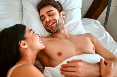 Birbirine aşık genç bir çiftin sabahı. Güzel bir Koreli kadın ve kaslı bir adam açık modern bir yatak odasında battaniyenin altında yatıyor..