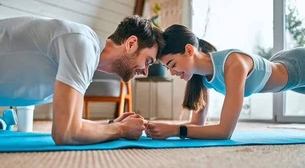 Casal Bonito Sportswear Fazer Uma Prancha Exercício Sobre Tapetes Sala — Fotografia de Stock