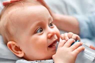 Annesine bakarken biberondan süt içen tatlı bir bebek. Anne oğlunu biberondan besliyor. Küçük çocuk evde süt içiyor..