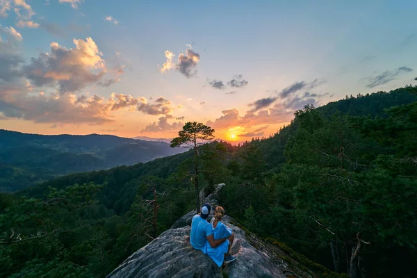 山の中の雲の後ろから驚くべきオレンジ色の日の出 山の上に観光客のカップル 山の中の松林 山の風景 — ストック写真