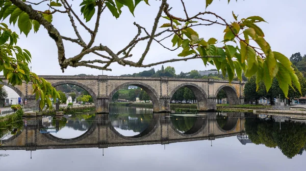 Puente viejo sobre el río con marco de árbol — Foto de Stock