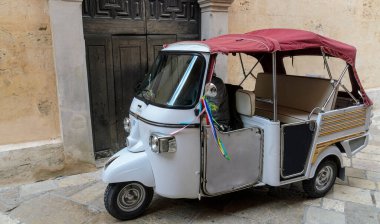 İtalya 'nın Matera köyünde üstü açık kapüşonlu üç tekerlekli bir araç.