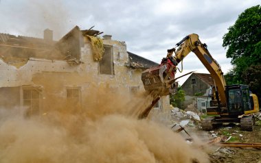 Toplayıcı kollu bir kazıcı tarafından bir konutun yıkılması Avusturya 'da büyük bir toz bulutuna neden oldu.