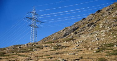 High-voltage power line on the autumnal Bernina Pass in the canton of Graubuenden, Switzerland