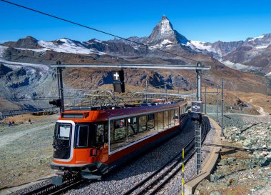 Gornergrat Demiryolu treni ön planda ve Matterhorn zirvesi arka planda Zermatt, İsviçre 'de güneşli bir sonbahar gününde
