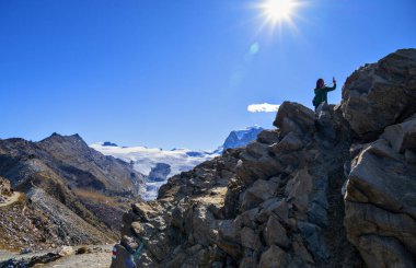 Kadın turist arka planda Monte Rosa 'nın buzullarıyla Gornergrat' ta selfie çekiyor, İsviçre