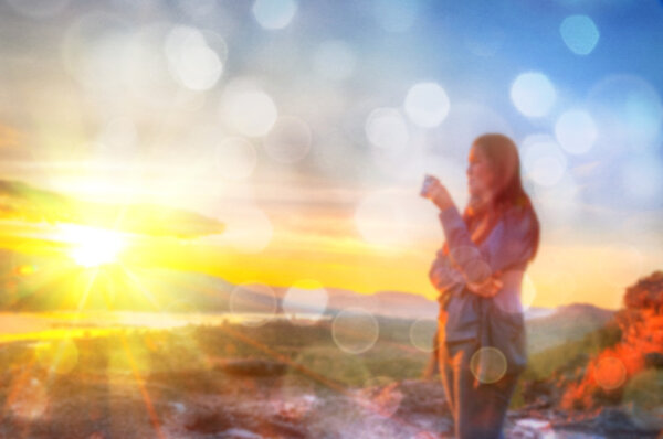 Аннотация Blurred and soft photo of Women on hilltop with bokeh of sunrise on the natural background
