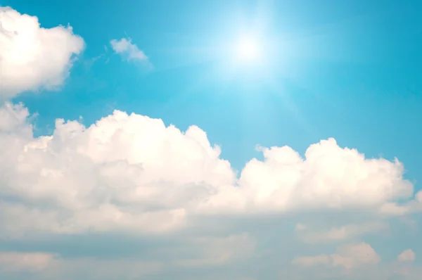 青い空と輝く太陽と白い雲の背景 — ストック写真