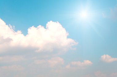 Arka plan mavi gökyüzü ve güneş parlıyor ile beyaz bulutlar