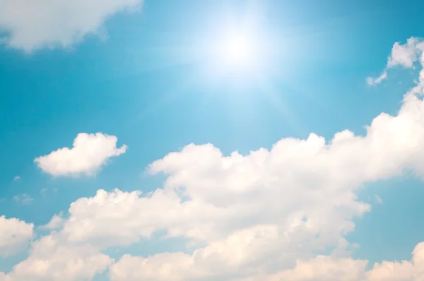 青い空と輝く太陽と白い雲の背景 — ストック写真