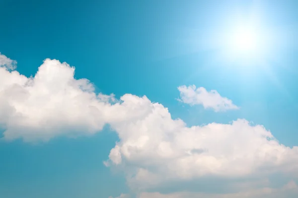 青い空と輝く太陽と白い雲の背景 — ストック写真