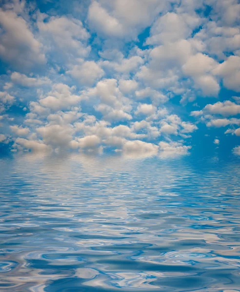 Superficie ondulada de agua con nubes y fondo del cielo — Foto de Stock