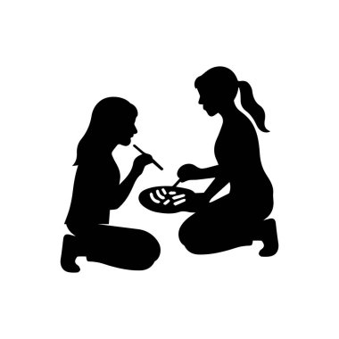 İki kadın birlikte abur cubur yiyor.