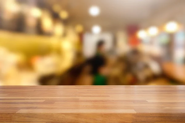 Mesa de madeira vazia e fundo café borrado — Fotografia de Stock