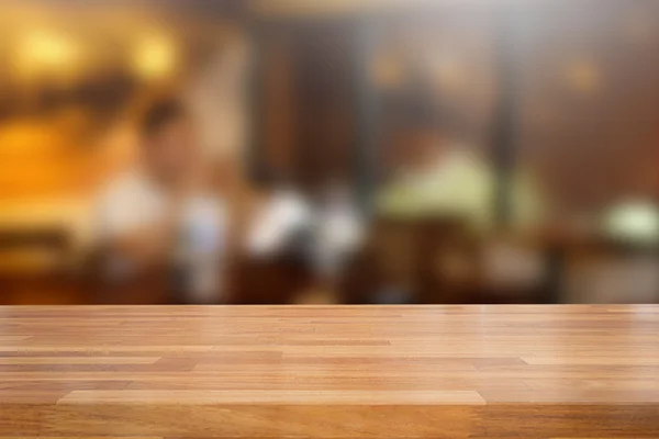 Meja kayu kosong dan latar belakang kafe yang kabur — Stok Foto