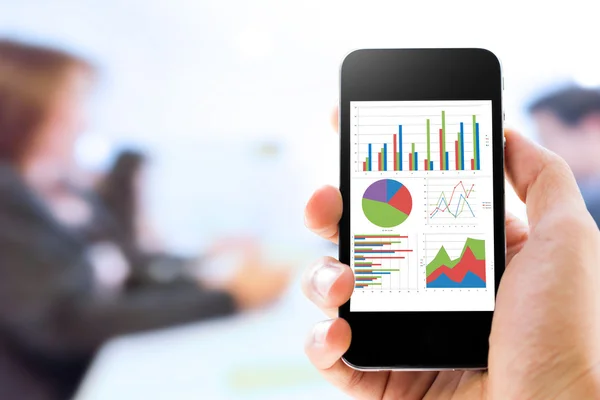 Close-up hand holding mobile phone with analyzing graph — Stock Photo, Image