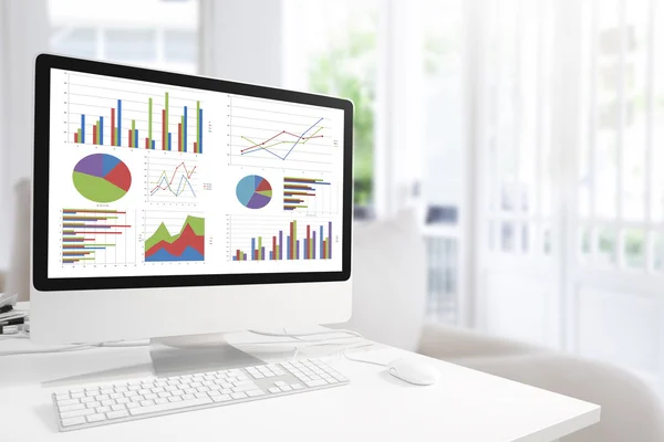 Modern computer with keyboard and mouse on table showing charts — Stock Photo, Image