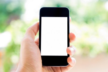 yakın çekim el bulanık doğa arka plan ile akıllı telefon tutarak