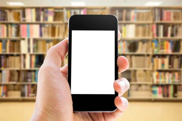 Mano che tiene lo smartphone sullo sfondo della biblioteca — Foto Stock