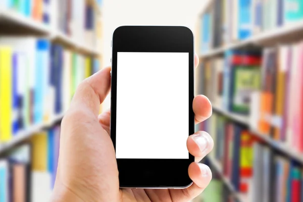 Mano che tiene lo smartphone sullo sfondo della biblioteca — Foto Stock