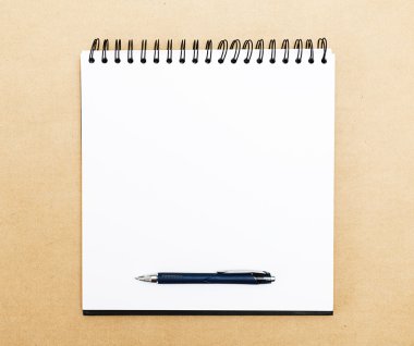 Ofis masasında kalem olan boş not defteri