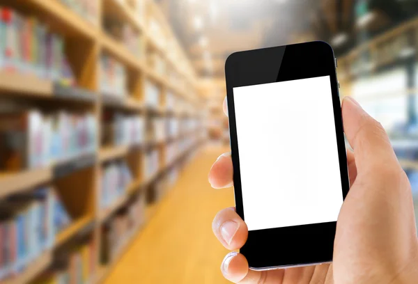 Hand holding smart phone on library background — Stock Photo, Image