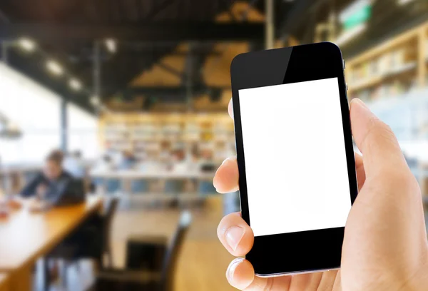 Hand holding smart phone on library background — Stock Photo, Image