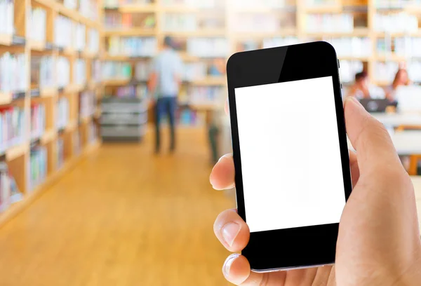 Mano sosteniendo teléfono inteligente en el fondo de la biblioteca —  Fotos de Stock