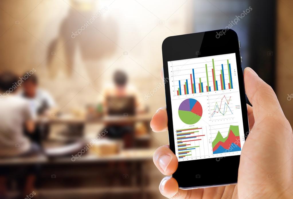 hand holding mobile phone with analyzing graph