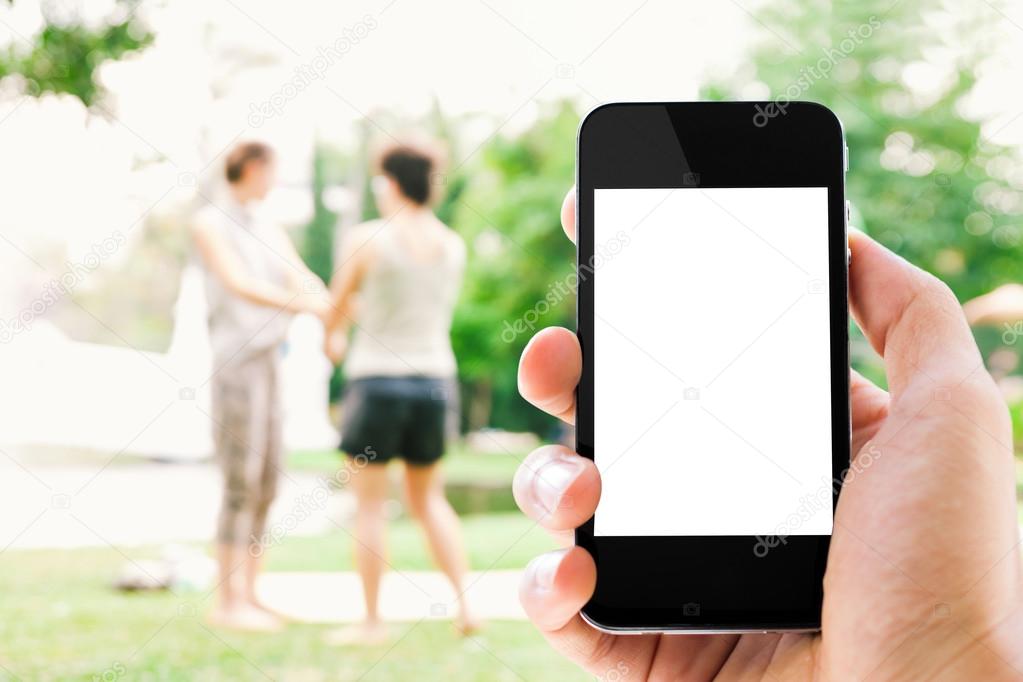  hand holding smart phone outdoor scene