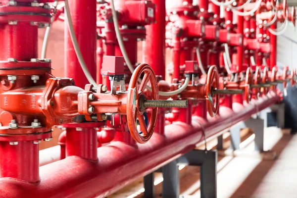 Una fila de fuego de color rojo que combate el sistema de tuberías de suministro de agua —  Fotos de Stock