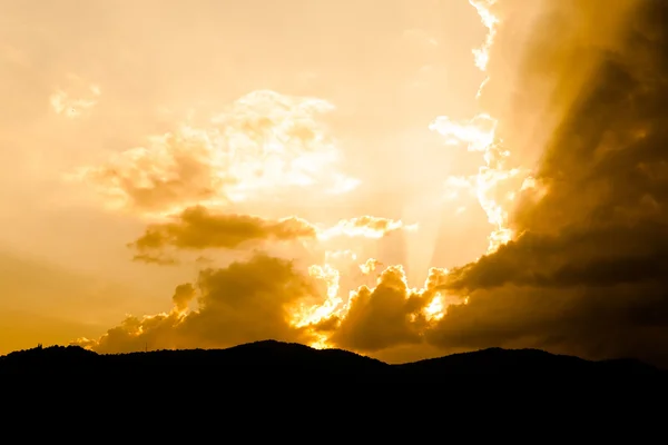 Beautiful dramatic sky with sun rays. over mountain — Stock Photo, Image