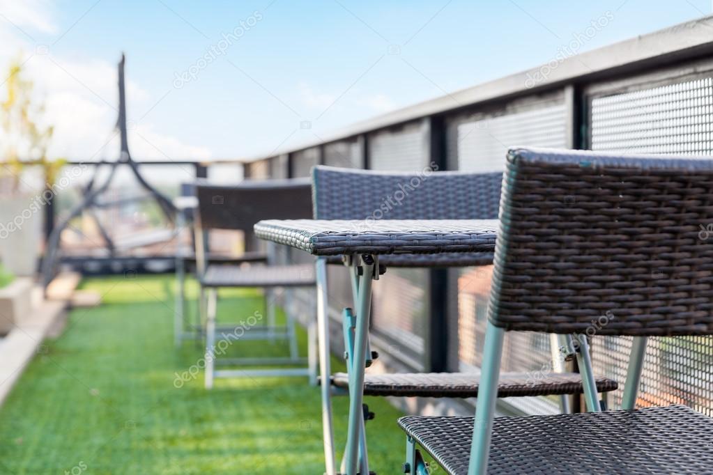 wicker chair  and a table on an open terrace with blue sky