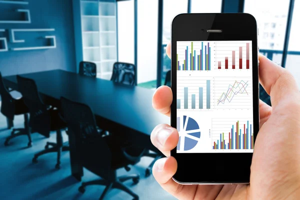 Closeup hand holding mobile phone with analyzing graph — Stock Photo, Image