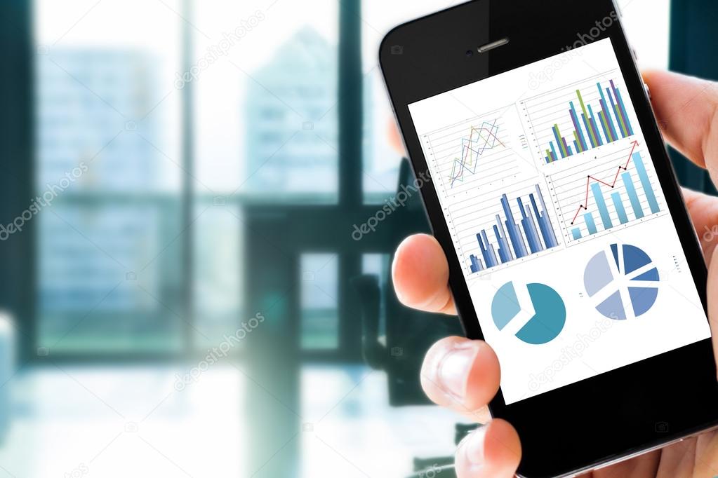 Closeup hand holding mobile phone with analyzing graph