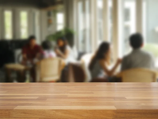 Mesa de madeira vazia e pessoas desfocadas no fundo do café — Fotografia de Stock