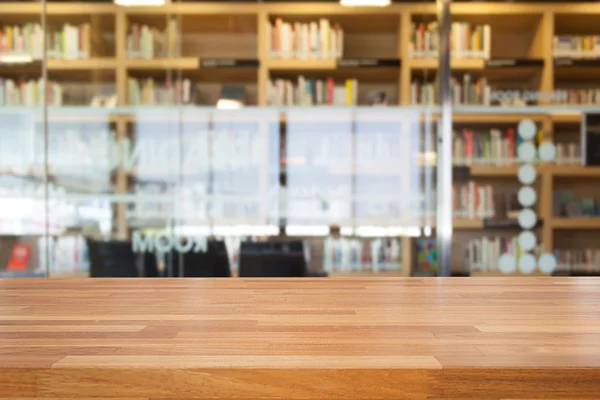 Lege houten tafel en moderne bibliotheek achtergrond — Stockfoto