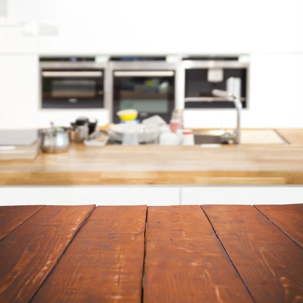 Meja kayu kosong dan latar belakang dapur yang kabur — Stok Foto