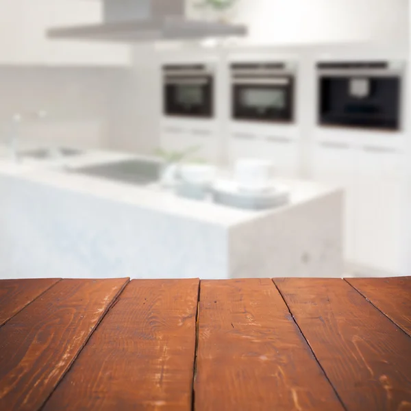 Lege houten tafel en wazig keuken achtergrond — Stockfoto