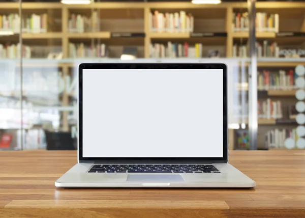 Ordenador portátil en la mesa, en el fondo de la estantería, pantalla en blanco — Foto de Stock