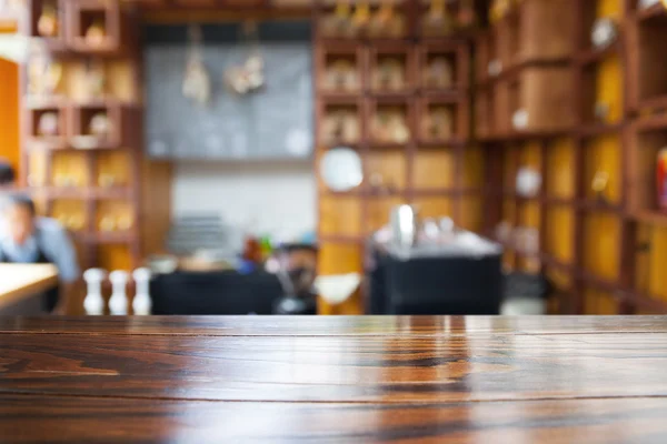 Table en bois vide et fond de café flou — Photo